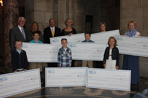 Winners pose with their checks and with Treasurer Stenberg, Rod Wagner of the Nebraska Library Commission, and Deborah Goodkin of First National Bank of Omaha.