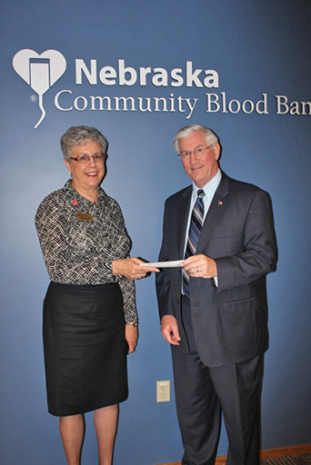 State Treasurer Don Stenberg delivers check for $9,136 to Phyllis Ericson, CEO of the Nebraska Community Blood Bank.